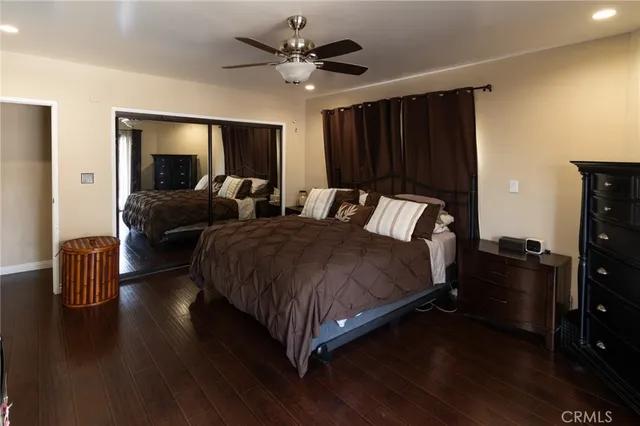 a spacious bedroom with a bed and wooden floor