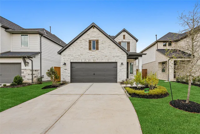 a front view of a house with a garden and plants