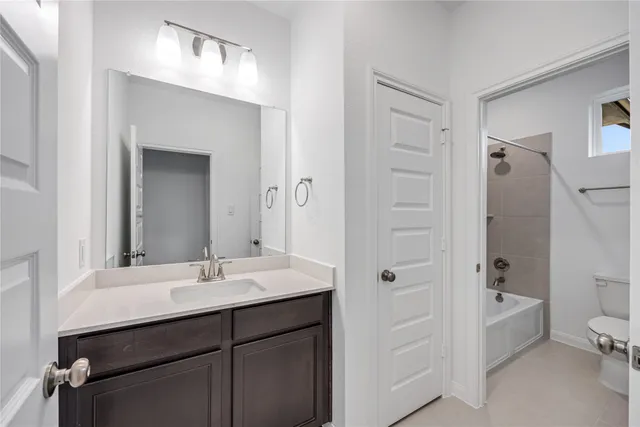 a bathroom with a bathtub shower sink vanity and toilet