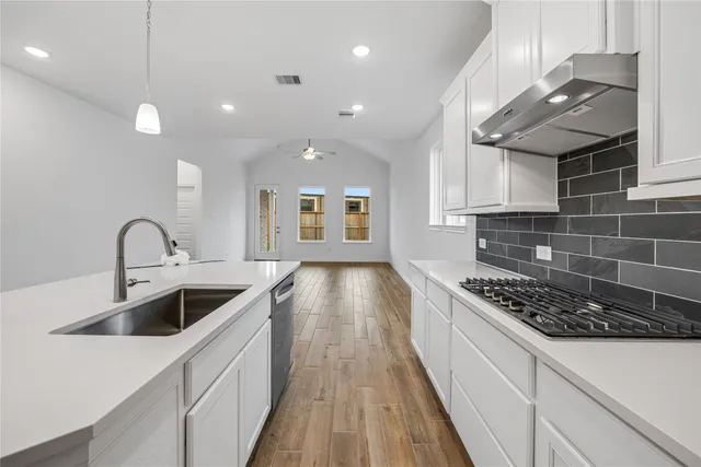 a kitchen with kitchen island a counter space a sink stainless steel appliances and cabinets