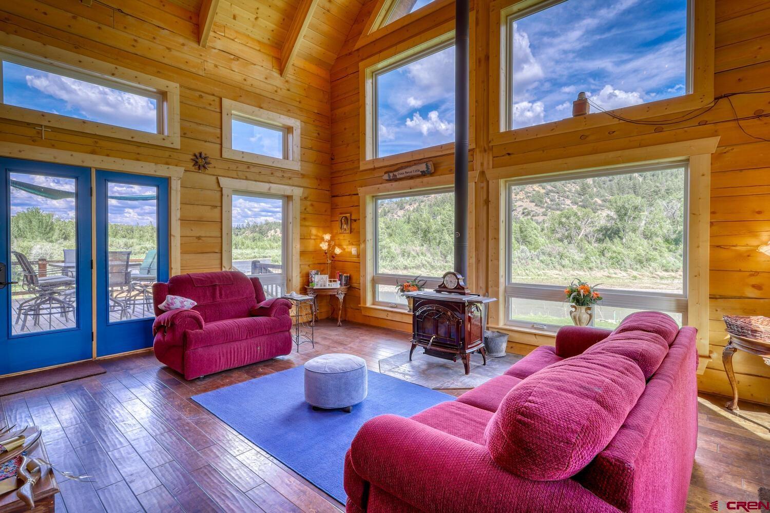 228 Estates Circle Road Pagosa Springs, CO 81147 - Photo 12 of 35 a living room with furniture floor to ceiling window and wooden floor