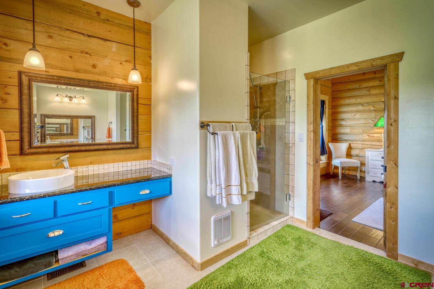 228 Estates Circle Road Pagosa Springs, CO 81147 - Photo 22 of 35 a bathroom with a sink a mirror and next to a window