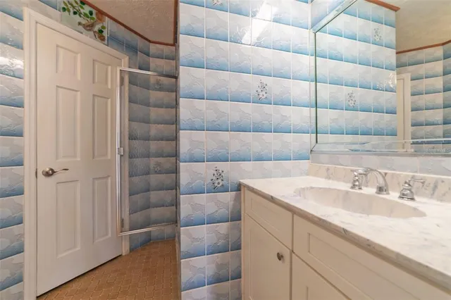 an empty room with wooden floor windows and fan