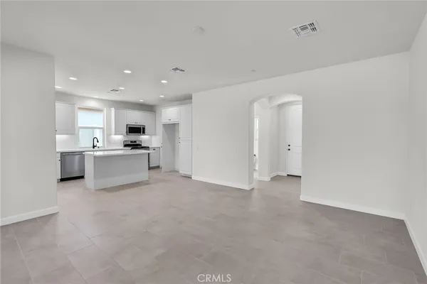 a view of an empty room with wooden floor and windows