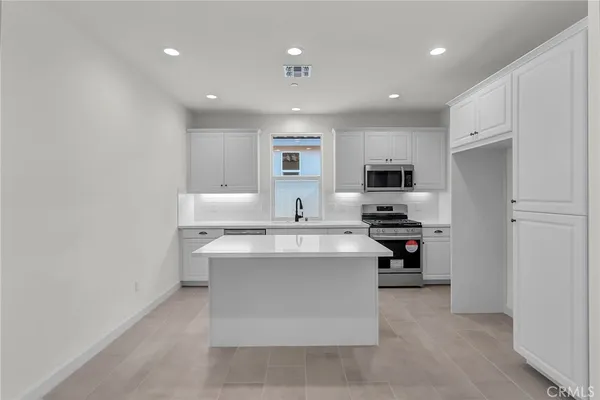 a kitchen with stainless steel appliances granite countertop a sink and a microwave