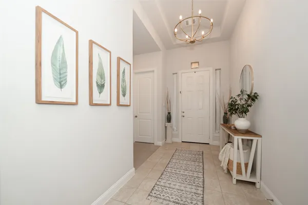 a view of a hallway with wooden floor and a chandelier