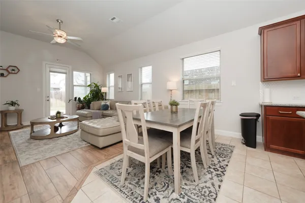 a living room with furniture a chandelier and a dining table