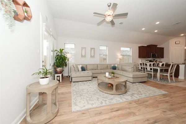 a living room with lots of furniture and view of kitchen