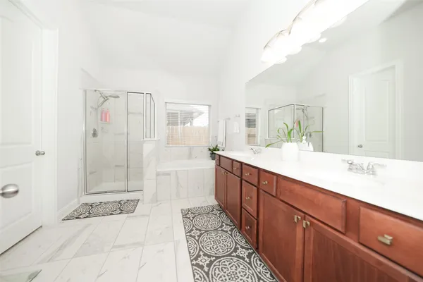 a spacious bathroom with a shower sink and mirror