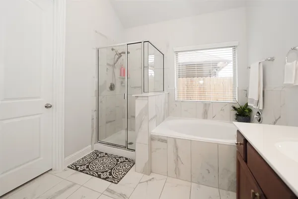 a bathroom with a tub sink and shower