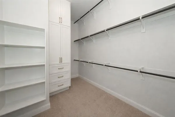 a view of walk in closet with empty racks