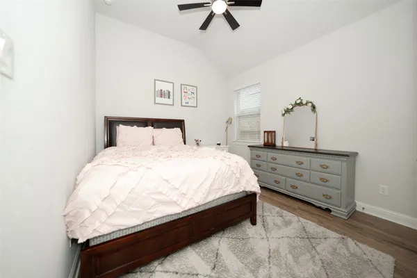 a bed room with a bed and a ceiling fan