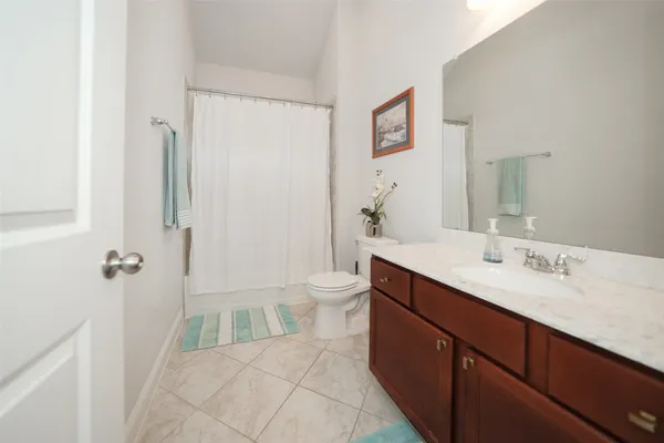 a spacious bathroom with a double vanity sink toilet mirror and shower