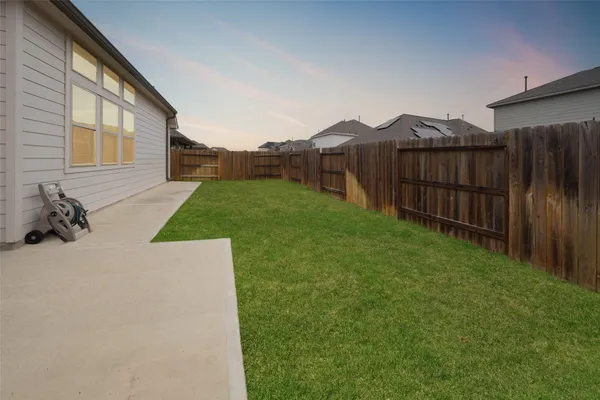 a view of a backyard with wooden fence