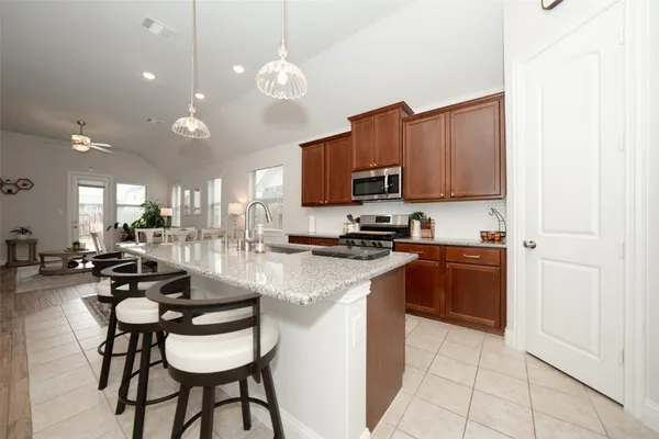 a kitchen with stainless steel appliances kitchen island granite countertop a stove a sink a microwave and a refrigerator