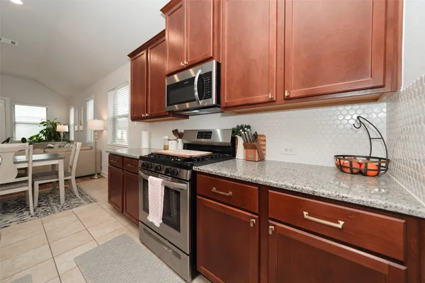 a kitchen with granite countertop cabinets and steel stainless steel appliances