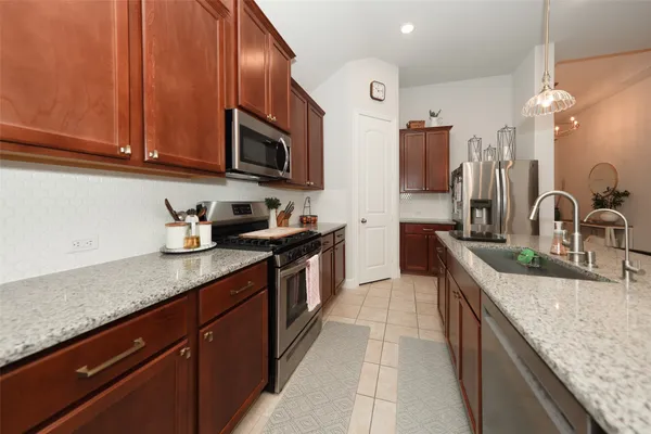 a kitchen with stainless steel appliances granite countertop a sink stove and cabinets