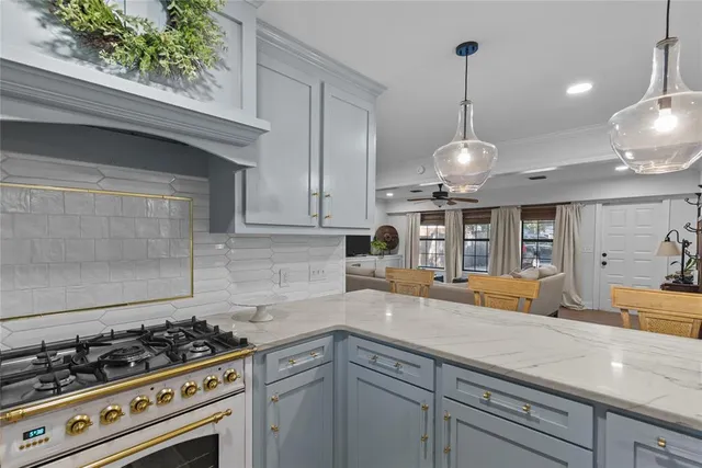 a kitchen with stainless steel appliances granite countertop a sink a stove and cabinets