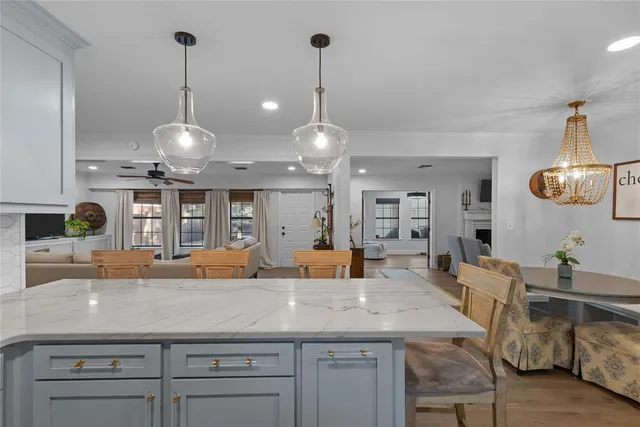 a kitchen with a counter space a sink and living room view