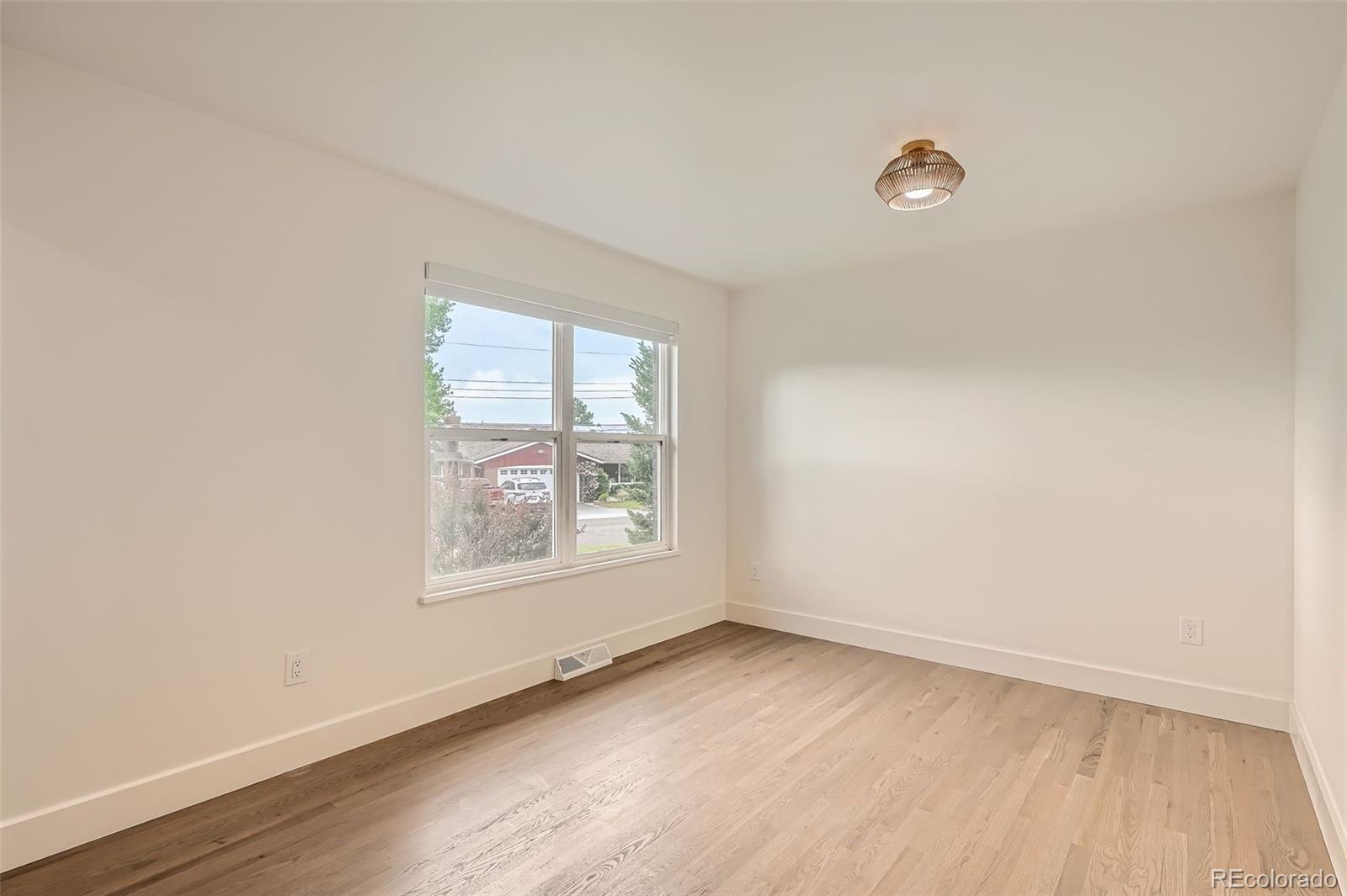 22 Rangeview Drive Wheat Ridge, CO 80215 - Photo 11 of 28 an empty room with wooden floor and windows