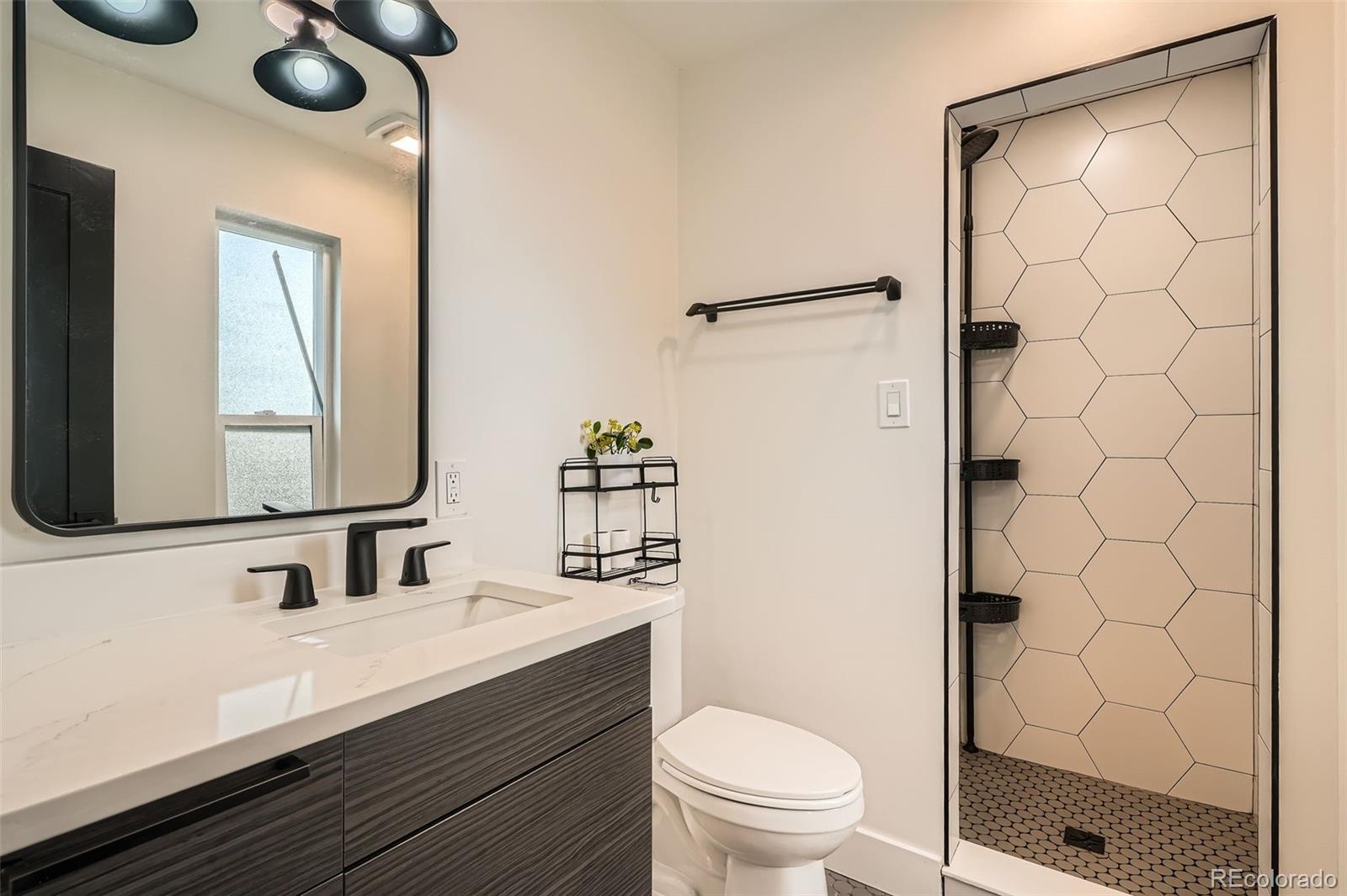 22 Rangeview Drive Wheat Ridge, CO 80215 - Photo 12 of 28 a bathroom with a sink a toilet and shower
