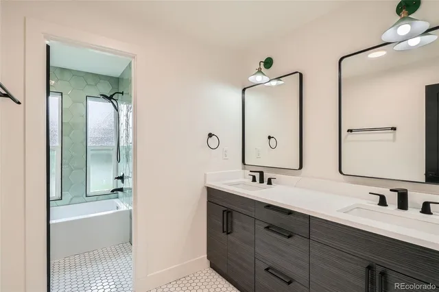a bathroom with a double vanity sink mirror and bathtub