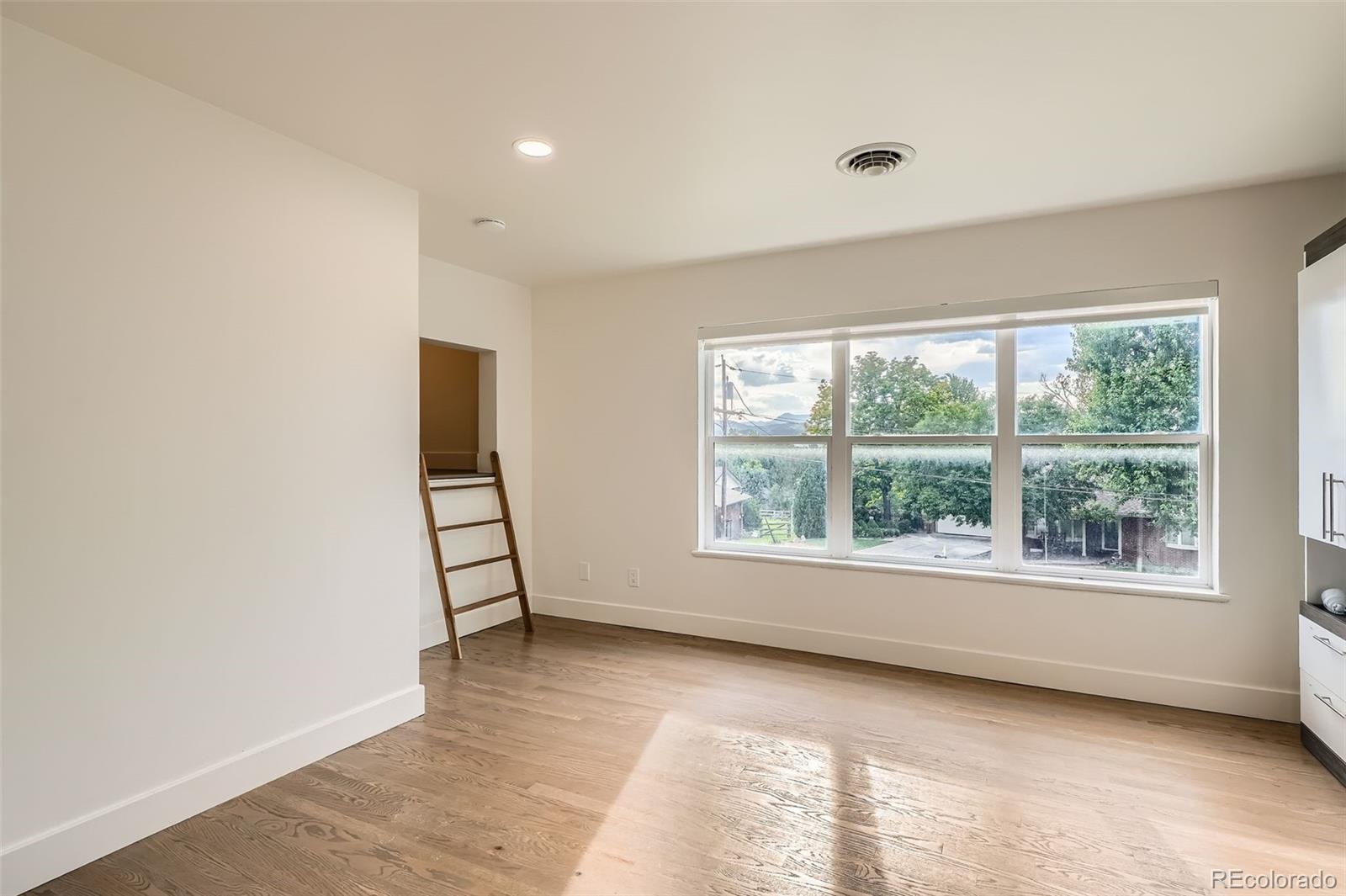 22 Rangeview Drive Wheat Ridge, CO 80215 - Photo 22 of 28 an empty room with wooden floor and windows