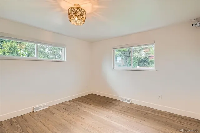 an empty room with wooden floor and window