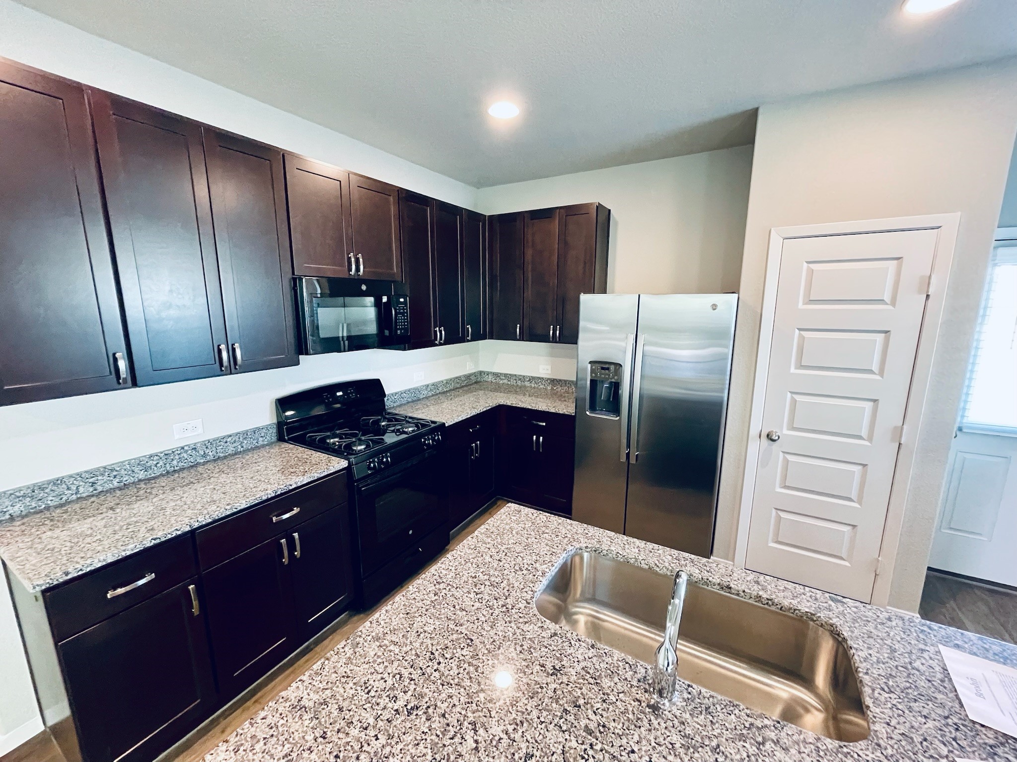 117 Huckleberry Lane Elgin, TX 78621 - Photo 8 of 34 Beautiful kitchen with stainless steel refrigerator and farmhouse sink.