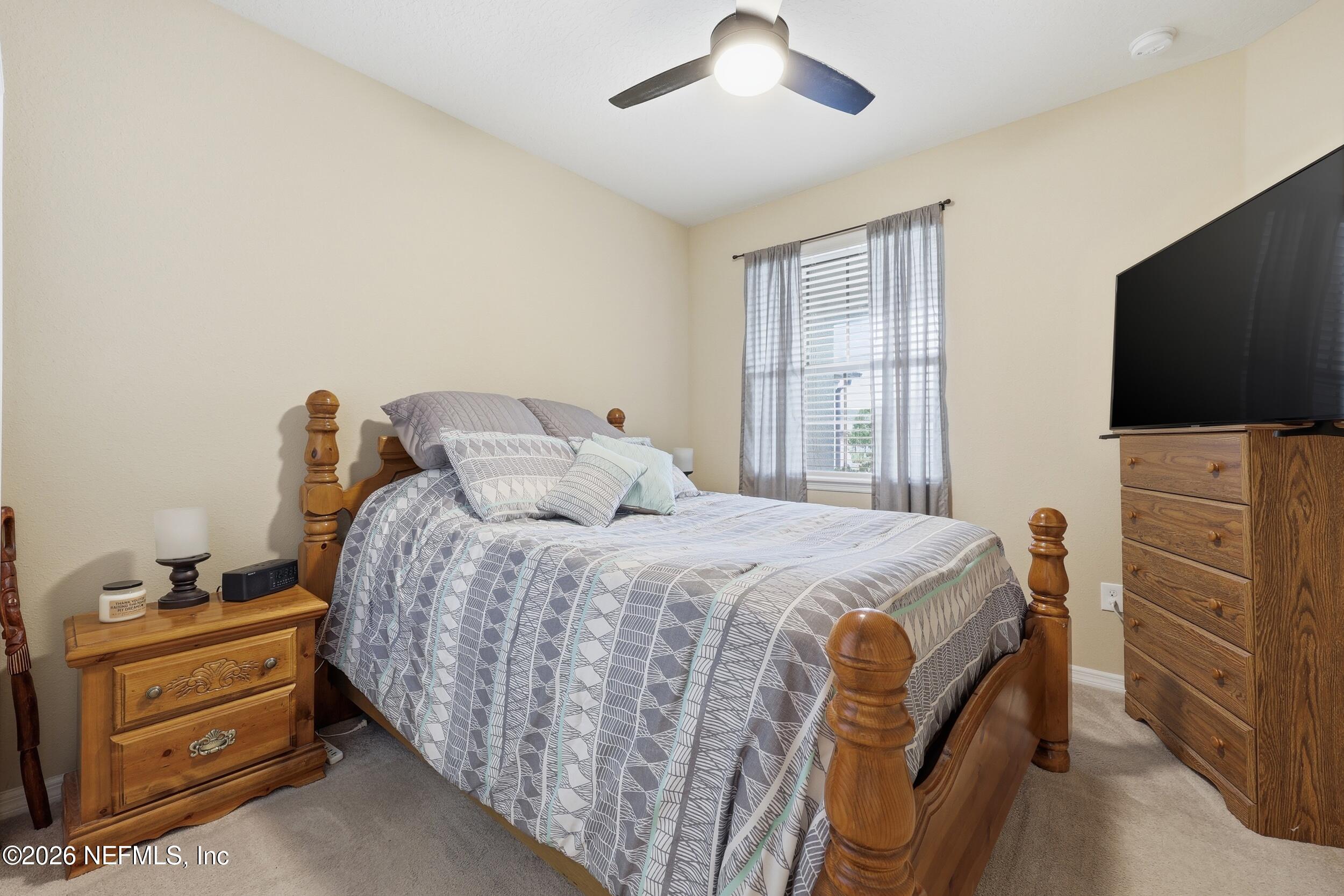 258 Rock Spring Loop St. Augustine, FL 32095 - Photo 21 of 31 a bedroom with a bed and a flat tv screen on dresser