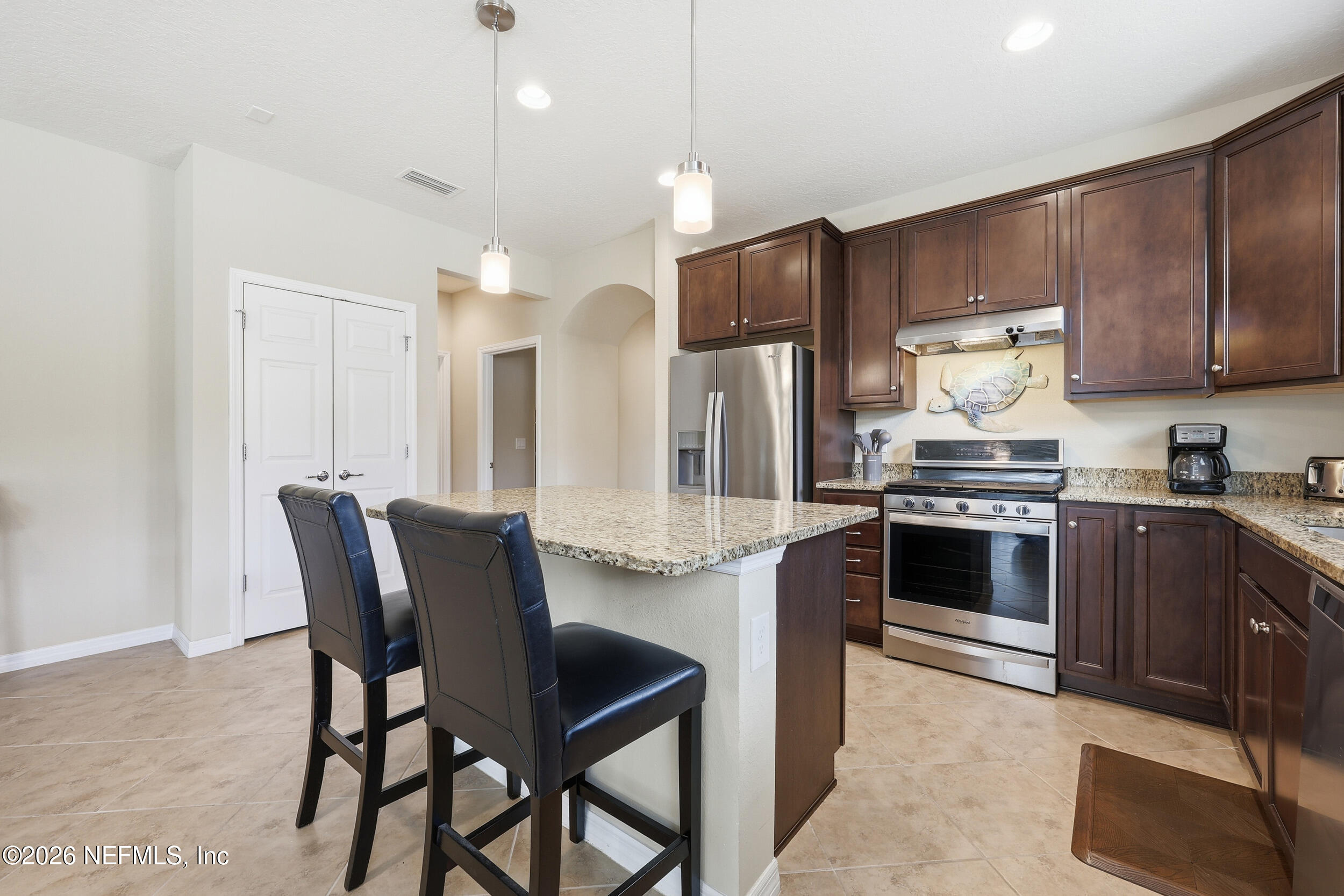 258 Rock Spring Loop St. Augustine, FL 32095 - Photo 7 of 31 a kitchen with granite countertop wooden cabinets and stainless steel appliances