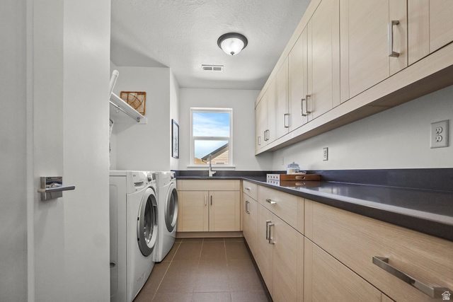 15008 South Springtime Road Draper, UT 84020 - Photo 31 of 37 Laundry room featuring cabinet space, separate washer and dryer, a textured ceiling, and dark tile patterned floors