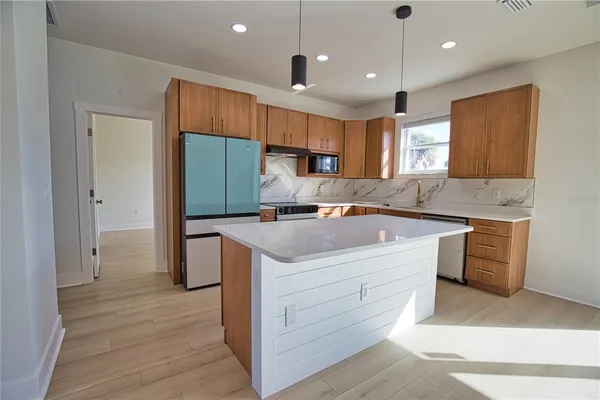 a kitchen with a stove a refrigerator and a sink