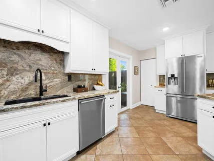a kitchen with stainless steel appliances granite countertop a refrigerator sink and cabinets