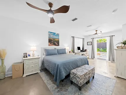 a spacious bedroom with a bed a window and a chandelier