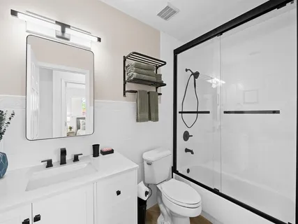 a bathroom with a sink a toilet and shower