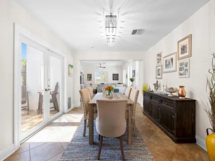 a view of a dining room with furniture a chandelier and wooden floor