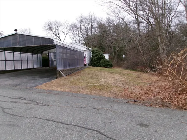 a backyard of a house with large trees and outdoor seating