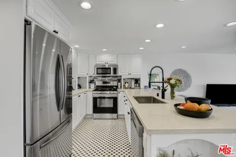 a kitchen with stainless steel appliances a refrigerator sink and microwave