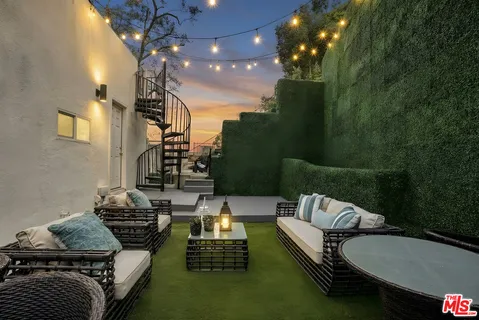 a view of a balcony with chairs and potted plants