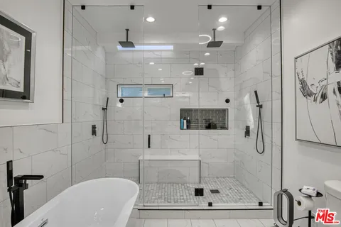a bathroom with a shower a mirror a toilet and a shower