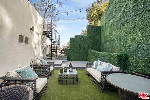 a view of a patio with couches table and chairs and potted plants