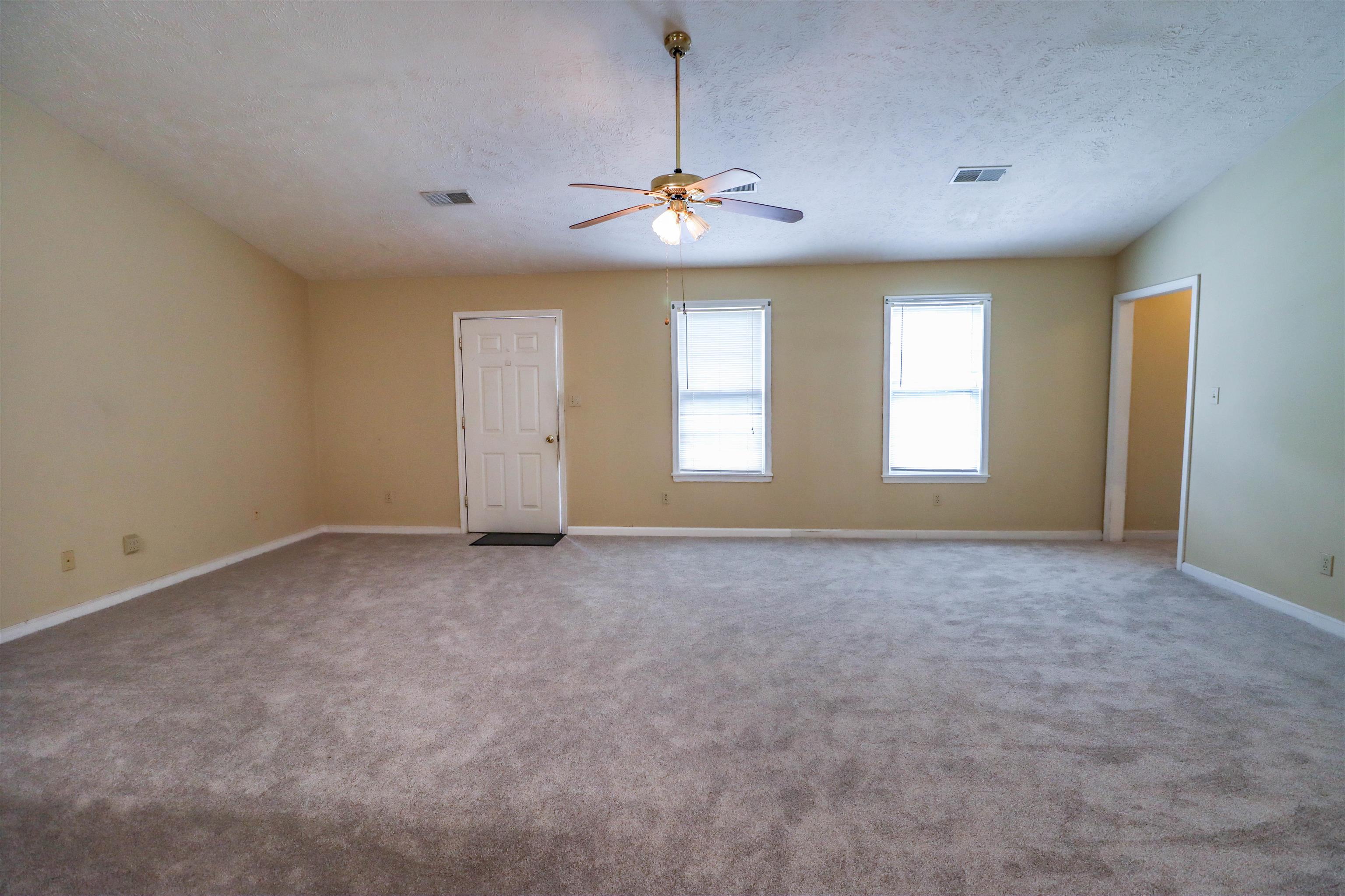 319 Jordan Street Ripley, TN 38063 - Photo 4 of 33 en empty room with windows and ceiling fan
