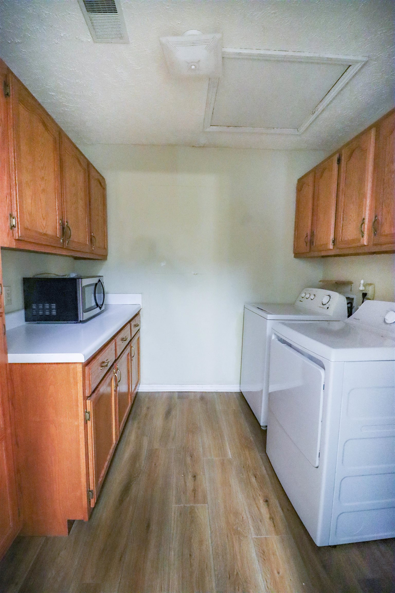 319 Jordan Street Ripley, TN 38063 - Photo 9 of 33 a utility room with stainless steel appliances granite countertop a sink a microwave oven a cabinets and wooden floor