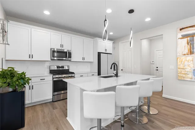 a kitchen with microwave a stove a sink a dining table and chairs