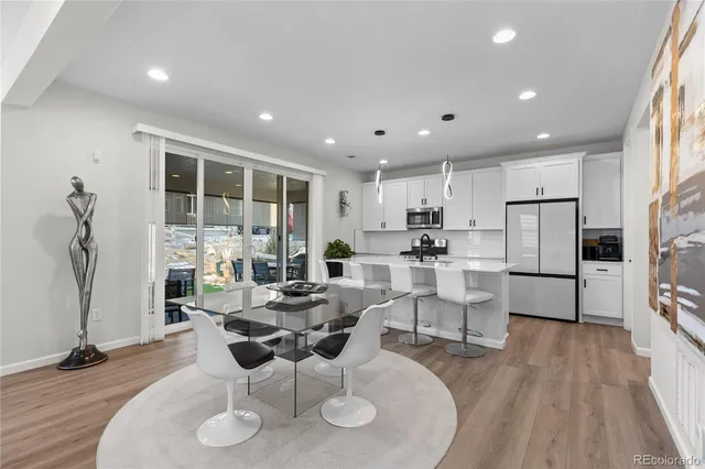 a living room with furniture a table and kitchen view
