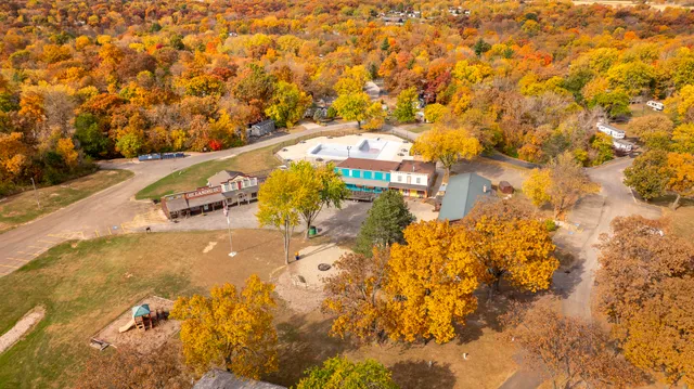 a view of a big house with a big yard and large trees