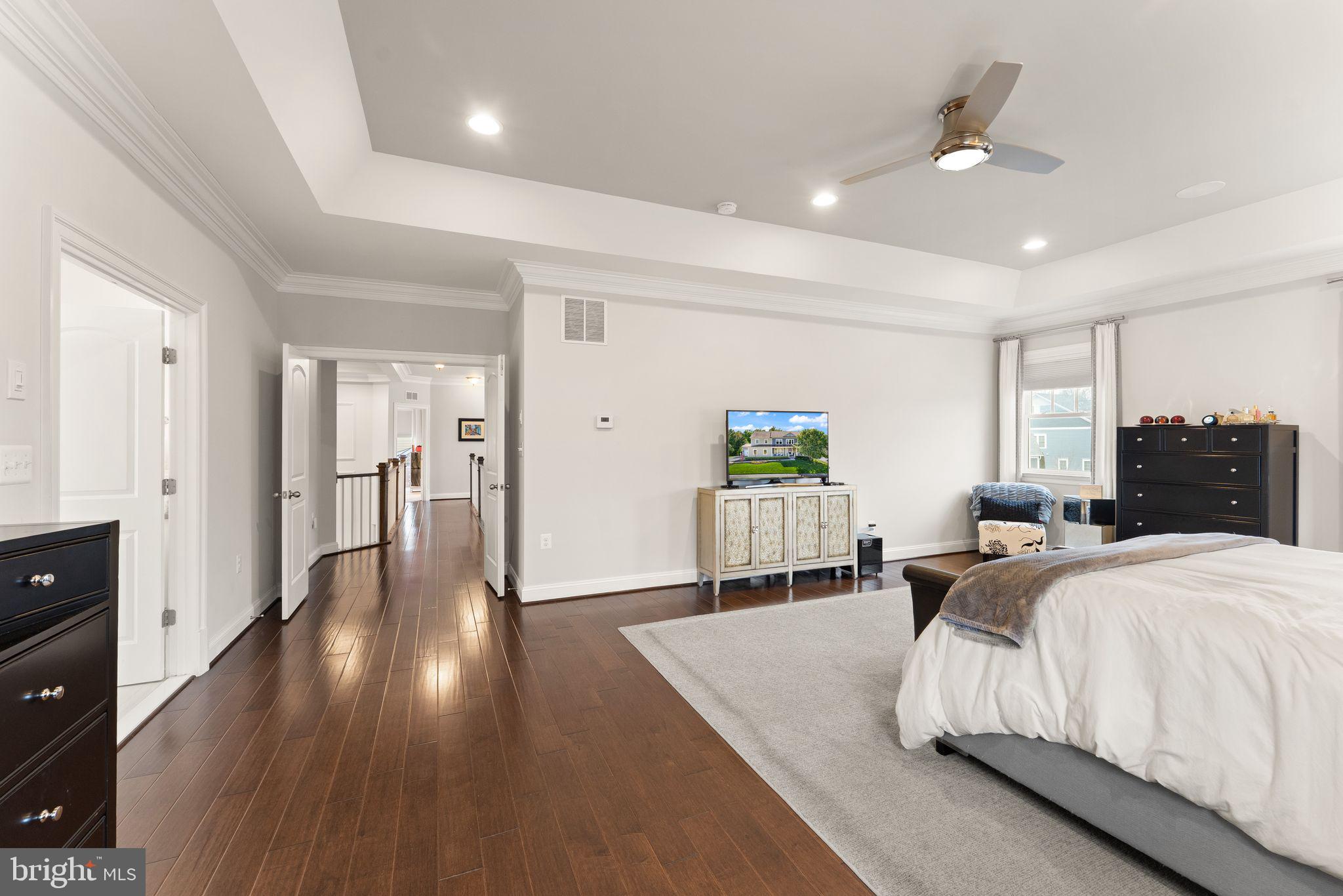 41865 Paddock Gate Place Ashburn, VA 20148 - Photo 35 of 99 a spacious bedroom with a bed and wooden floor