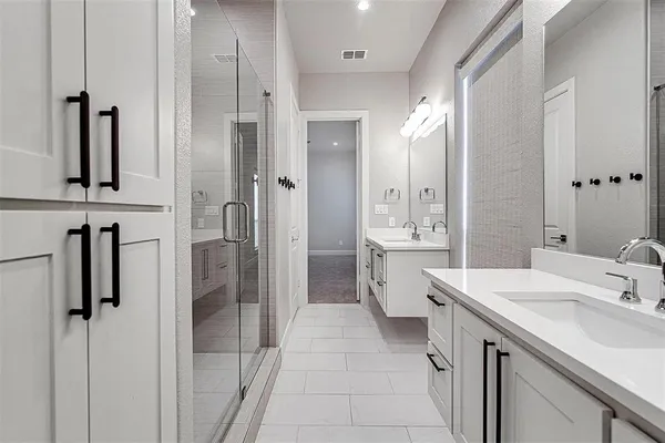 a bathroom with a double vanity sink a mirror and shower