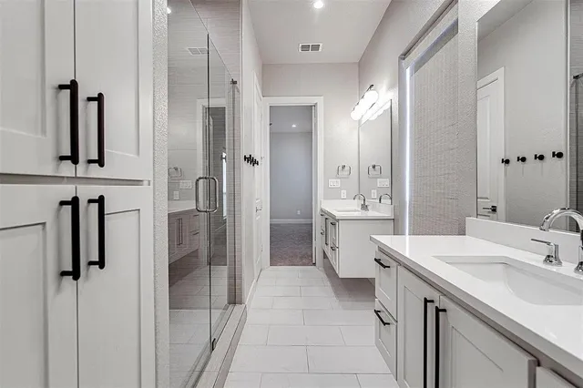 a bathroom with a double vanity sink a mirror and shower